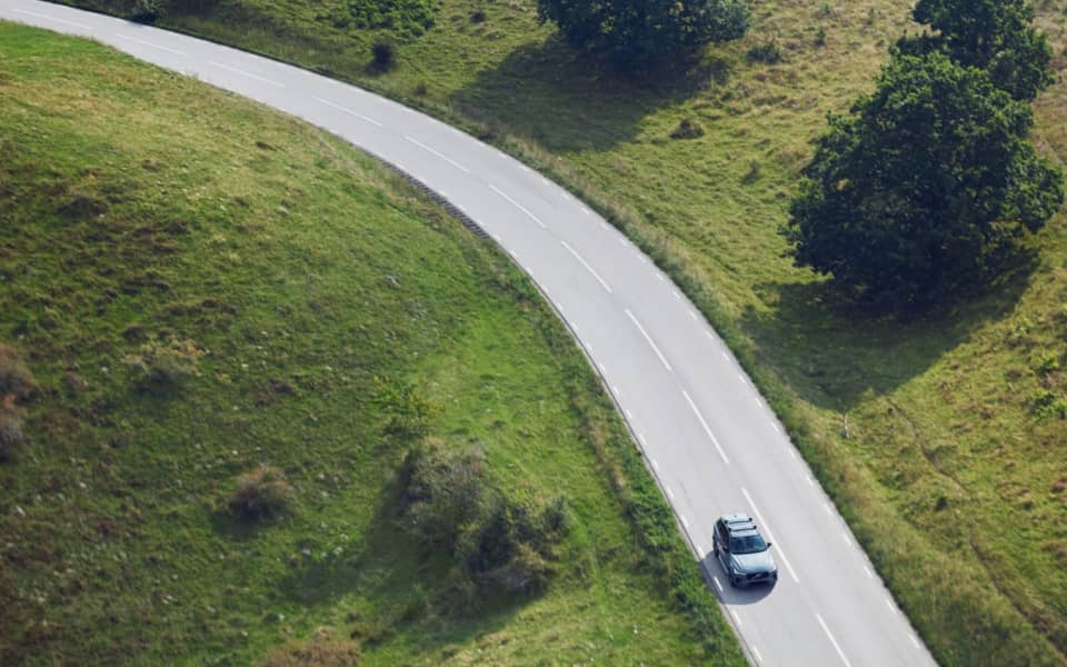 Oversiktsbilde av en Volvo EX30 som kjører på en landsbyvei.