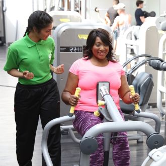 Gym instructor helping member at Vauxhall leisure centre