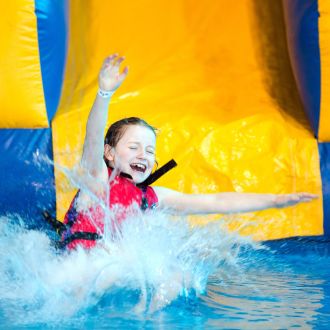 An image of a child going down an inflatable water slide