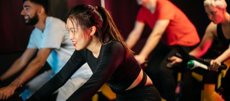 The image shows members enjoying a group cycle class with Better