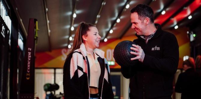 instructor with lady in gym holding medicine ball