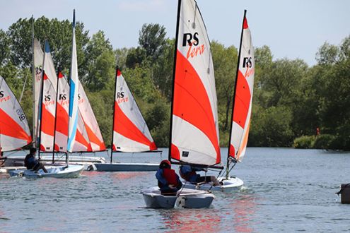 Lots of sailing dinghies on Stanborough lake, red and white sails 