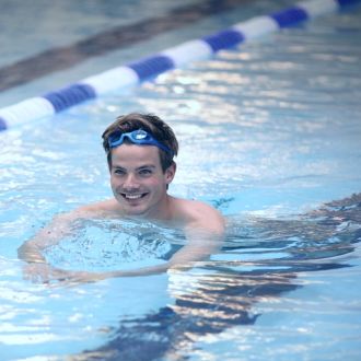 A man swimming Breaststroke in an indoor pool