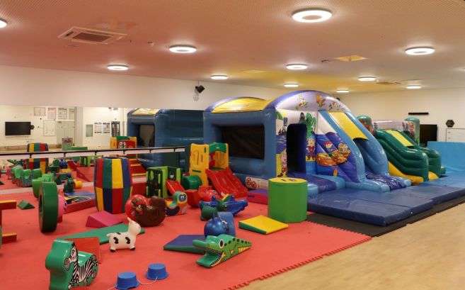 Full fun gym soft play party set up with bouncy castles, slides and toys