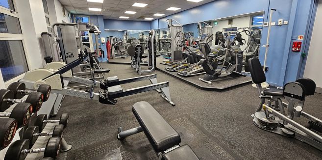Gym showing array of equipment stations, weights and mat area