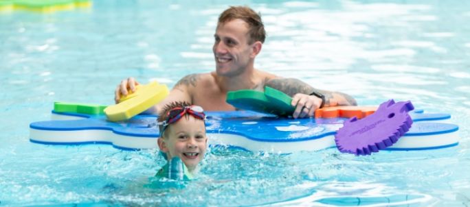 child playing with floats and parent