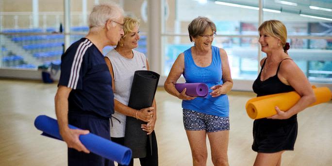People with mats before a group yoga class