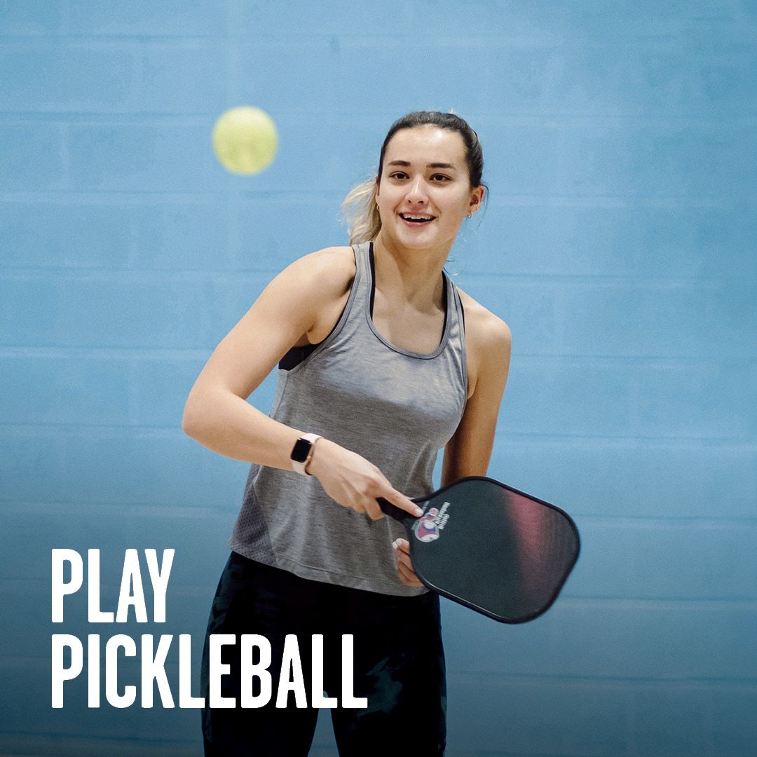 A smiling woman playing Pickleball