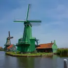 Green and Brown Windmills Next to a Lake in Zaanse Schans