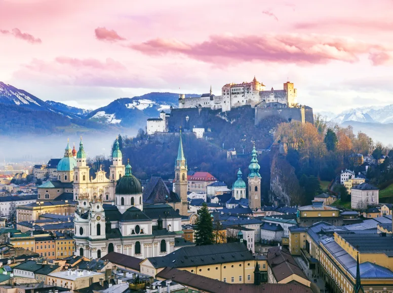 Overview of Salzburg with Mountain Backdrop at Sunset