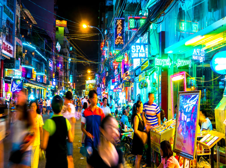 neon lights and bustling street market at night in saigon