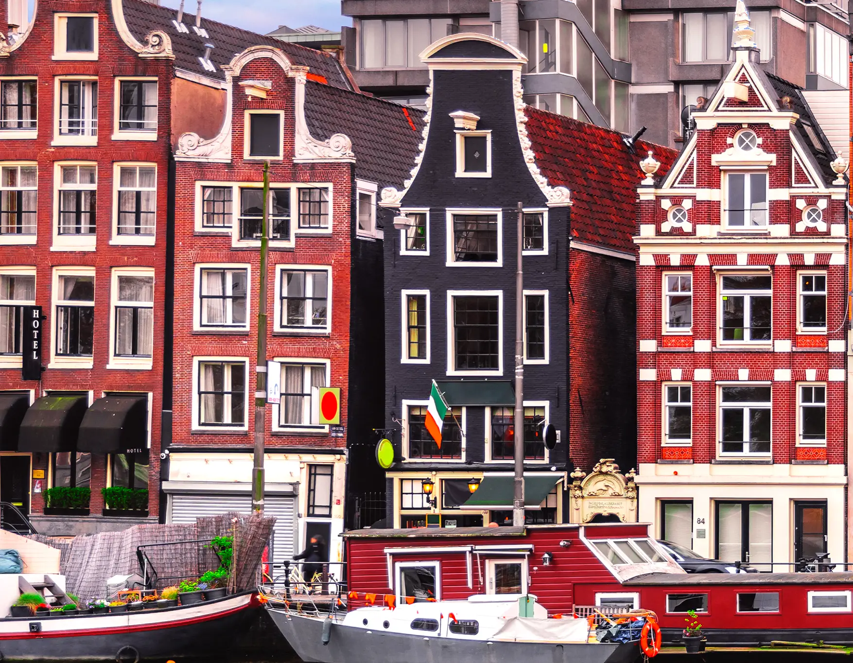 A Row of Colorful Red and Navy Gable Houses by a Canal