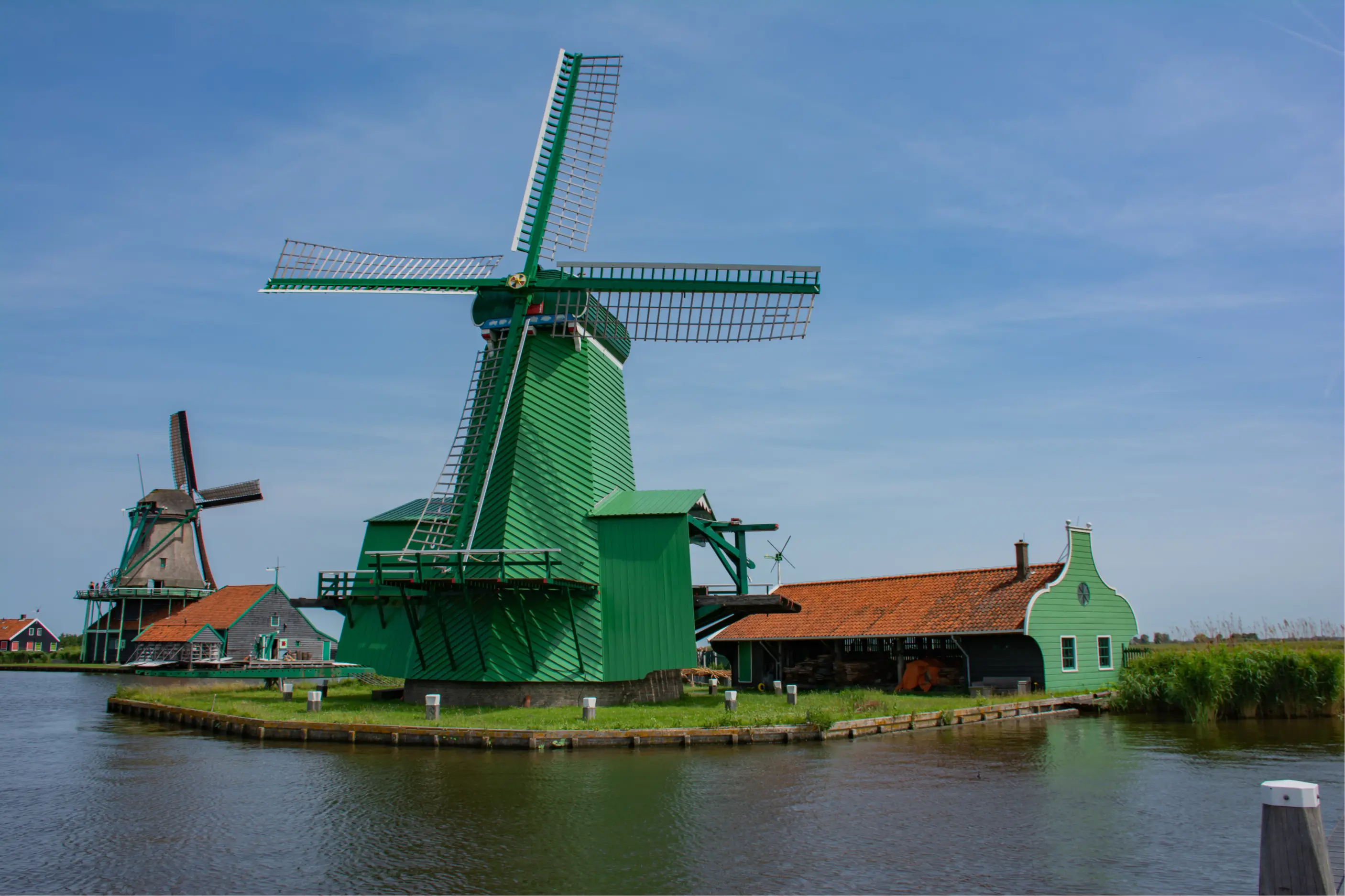 Green and Brown Windmills Next to a Lake in Zaanse Schans