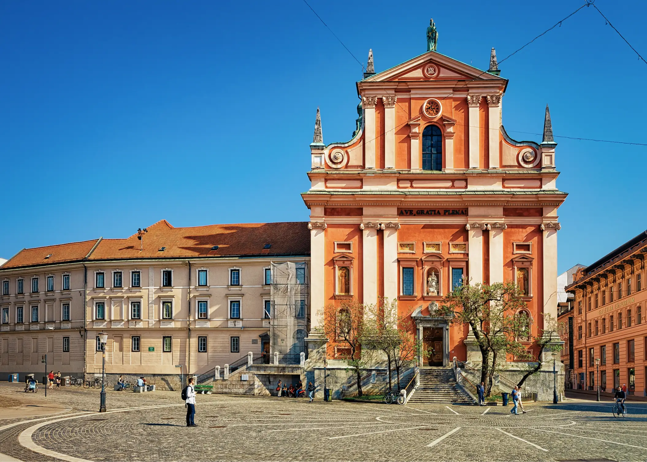 A City Square With a Pink and White Columned Building