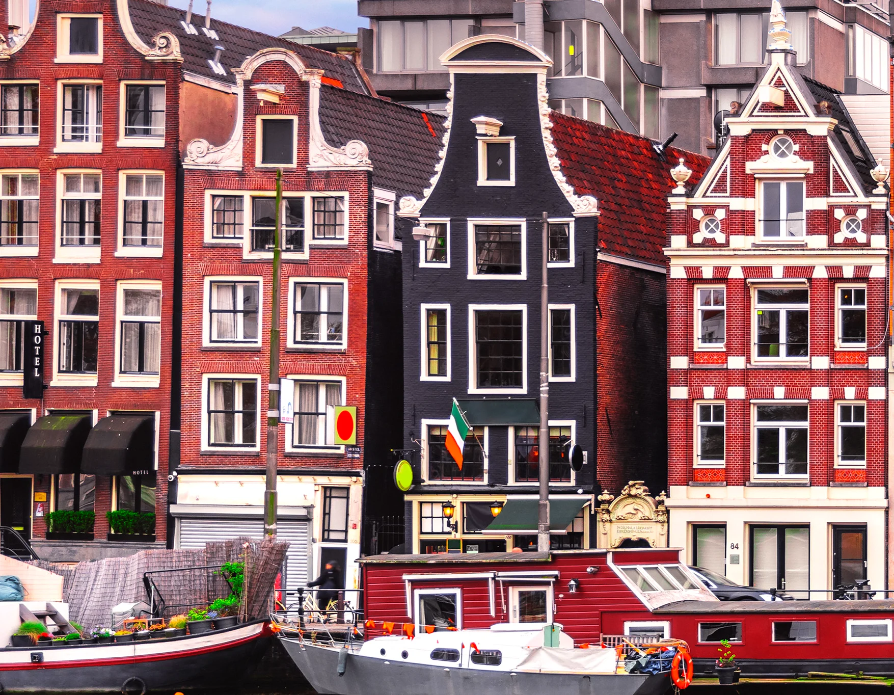 A Row of Colorful Red and Navy Gable Houses by a Canal