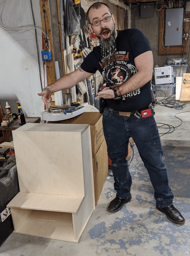 Picture of Crates McDade pointing at the bar-top arcade cabinet he's building with Dad.