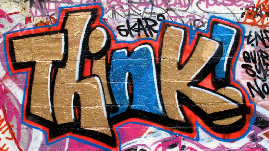 Graffiti-tagged wall that says, "Think!"