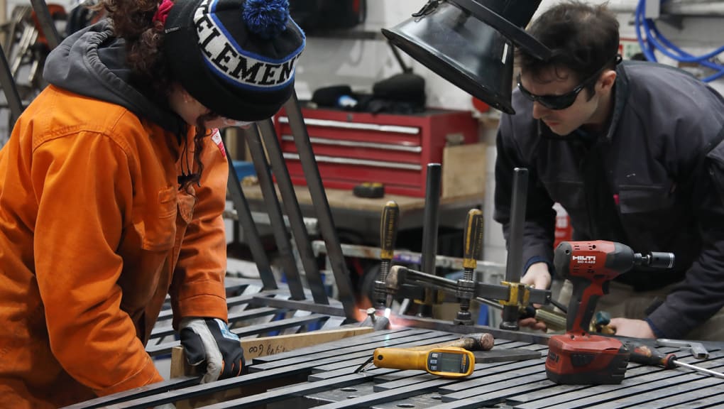 Two people working in a workshop on the construction of the swing bridge