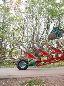 Packers - Kverneland Packomat compact and transported above ground level, dragged by tractor in a folded shape