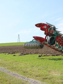 Packers - Kverneland Packomat compact and transported above ground level, dragged by tractor in a folded shape