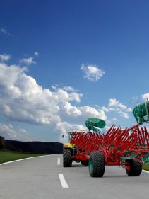 Packers - Kverneland Packomat compact and transported above ground level, dragged by tractor in a folded shape