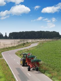 Packers - Kverneland Packomat compact and transported above ground level, dragged by tractor in a folded shape