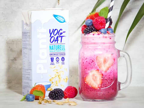 Rosa smoothie i glas med frukt på toppen