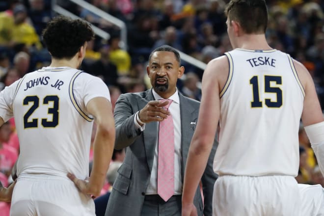 Michigan Wolverines basketball coach Juwan Howard (center).