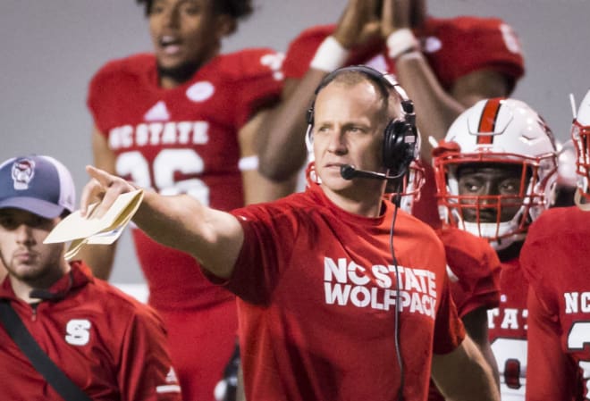 NC State Wolfpack football head coach Dave Doeren coaches from the sideline.