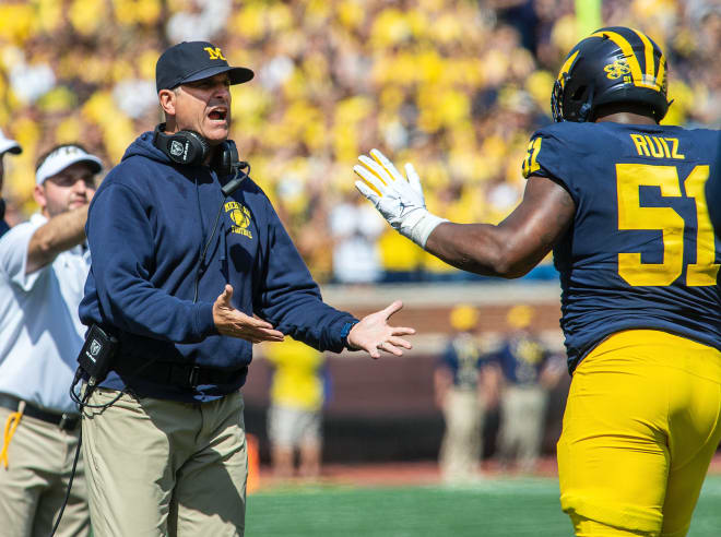 Michigan Wolverines football coach Jim Harbaugh (left) and Cesar Ruiz