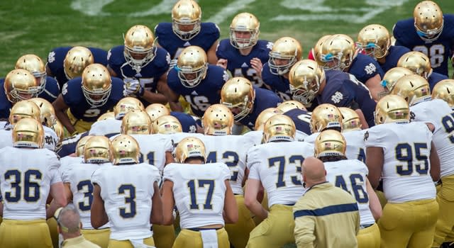 Notre Dame football players huddling together