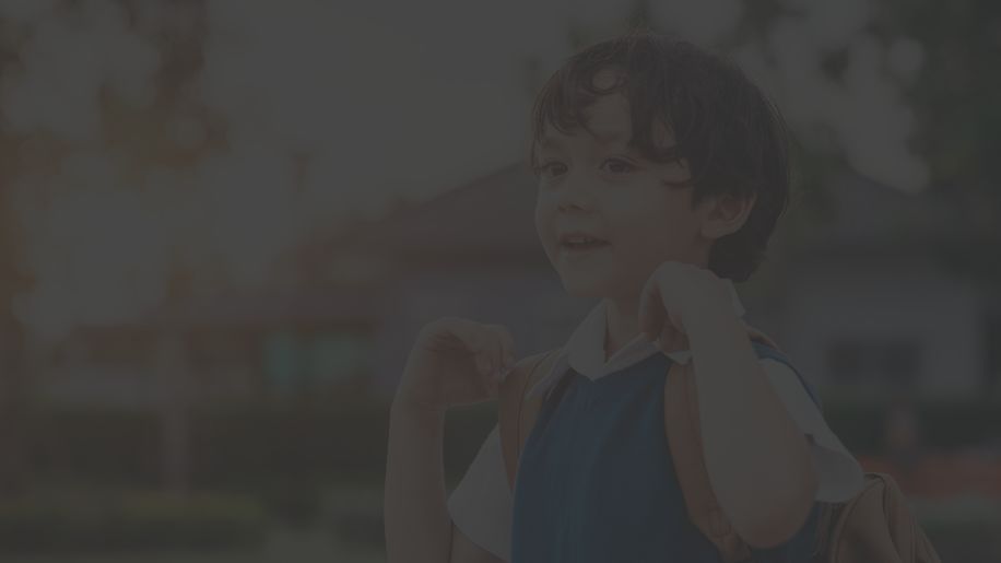 a healthy, happy vaccinated child with a backpack standing outside