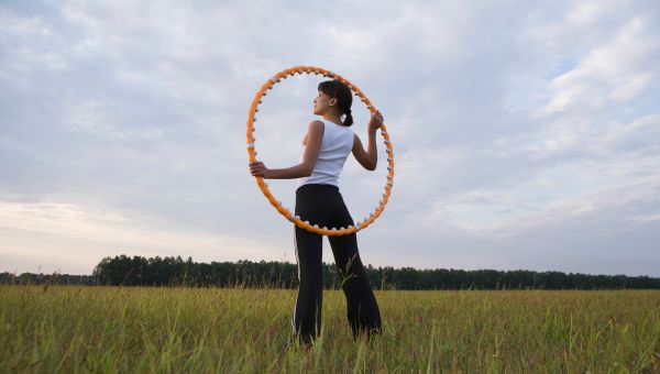 woman standing in field with hula hoop