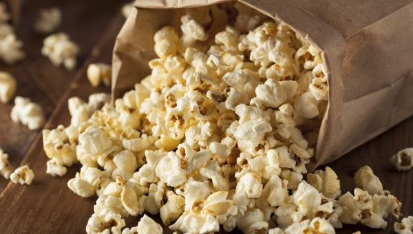 popcorn spilling out of a brown paper bag