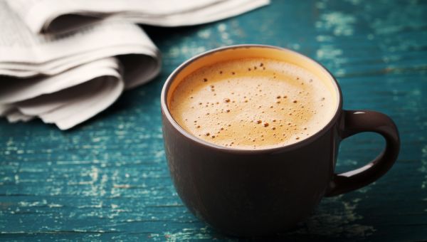 cup of coffee in a black cup against a blue background