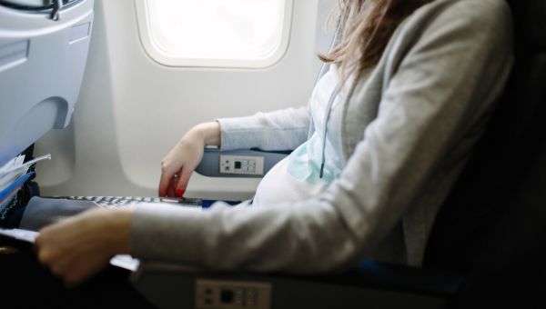 pregnant person sitting in an airplane seat