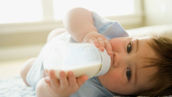 Infant holding bottle