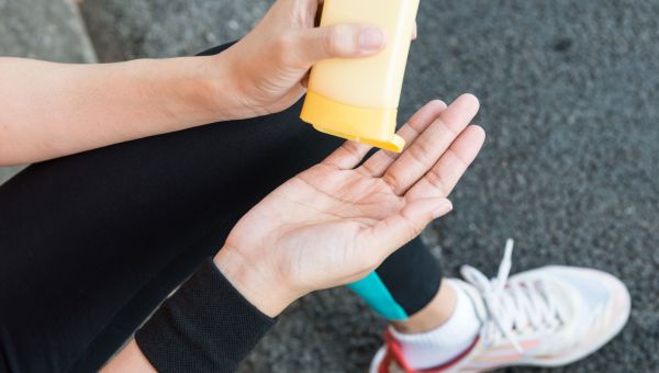 Woman rubbing sunscreen on her skin