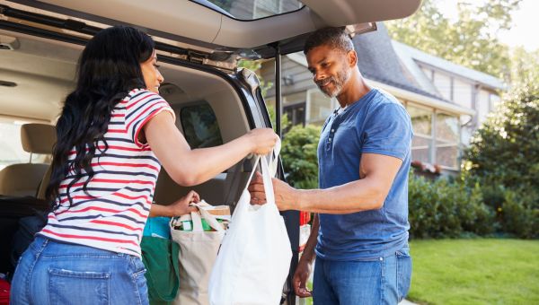Couple putting groceries in back of car