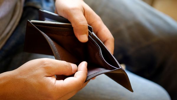 man looking in empty wallet