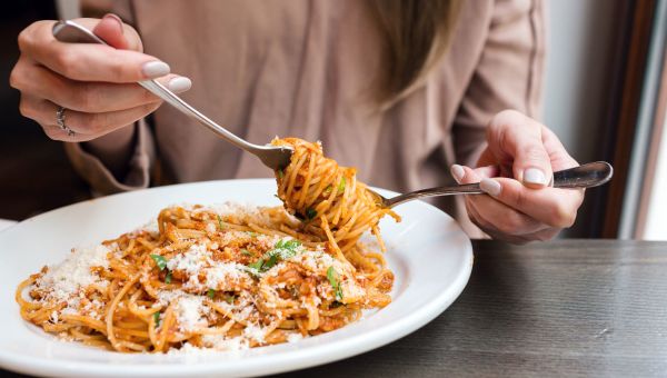 Young woman eating spaghetti