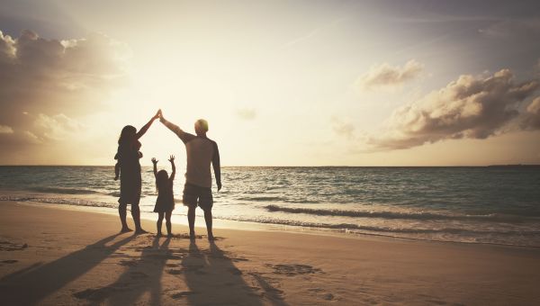 family walking on beach holding hands