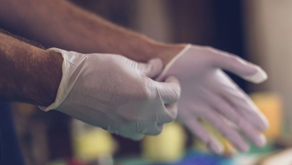 Surgeon putting on latex gloves