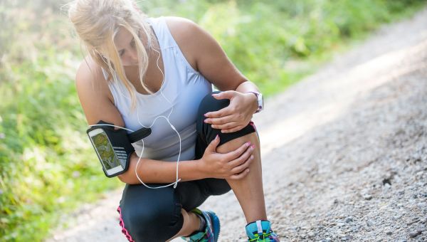 Woman experiencing knee pain after running