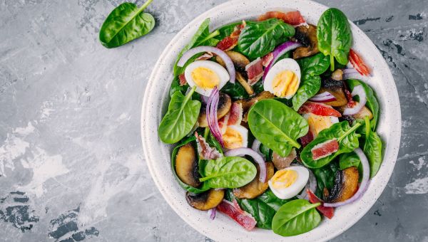 Spinach salad with eggs, bacon and red onions