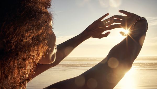 young black woman on beach with sun