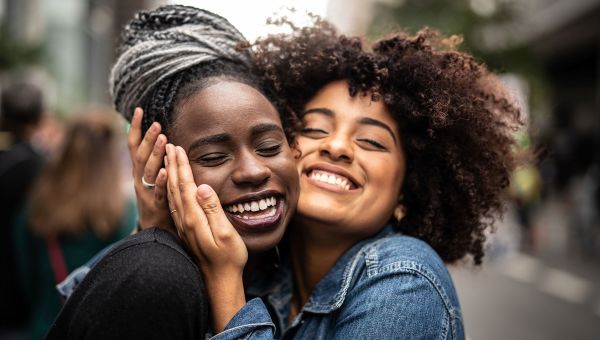 Two young black women embracing one another