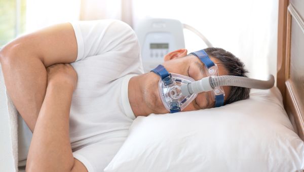 man sleeping with CPAP machine