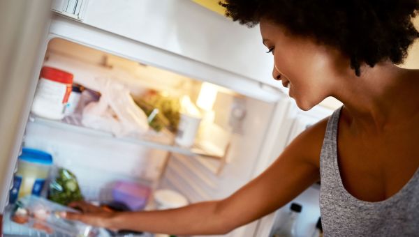 Woman reaching in fridge for healthy food