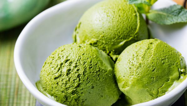 Three scoops of matcha ice cream in a bowl.